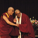 Tenzin Gyatso, the 14th Dalai Lama, exhorted a packed audience at Kresge Auditorium on Thursday to work toward a more compassionate world, emphasizing that a loving and ethical life can be based on any religion, or on no religion. Here he and Tenzin Priyadarshi, director of the Dalai Lama Center for Ethics and Transformative Values, share a word at the end of his talk.